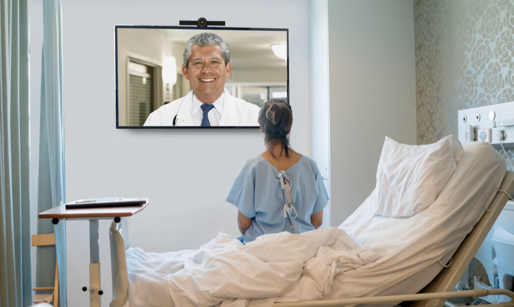 patient talking to a doctor on a TV in the hospital room
