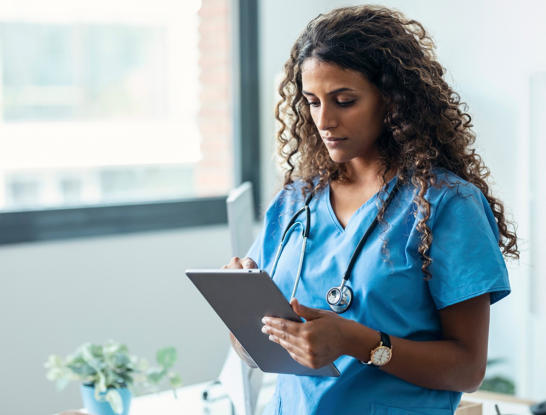 nurse holding a tablet and talking to a patient virtually