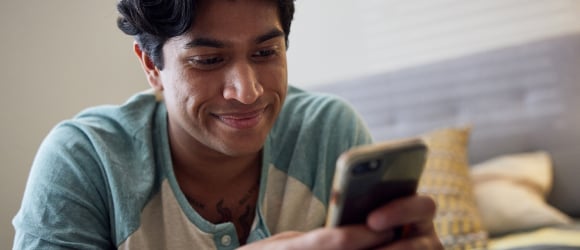 a patient smiling while talking to his provider on the phone