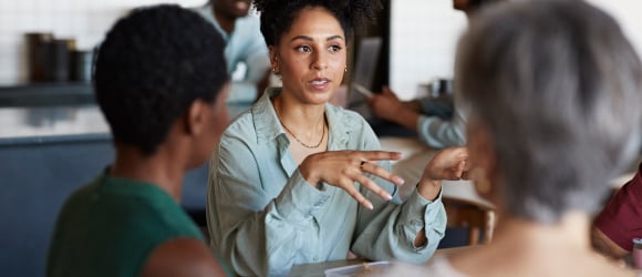 a woman explaning something to two other people