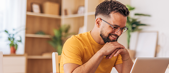 man on his laptop smiling