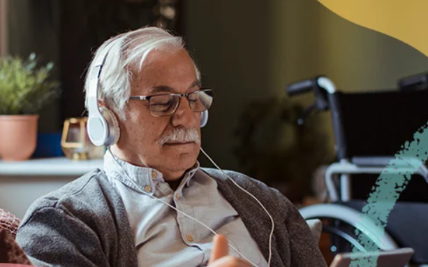 an older man with glasses and headphones looking at the tablet