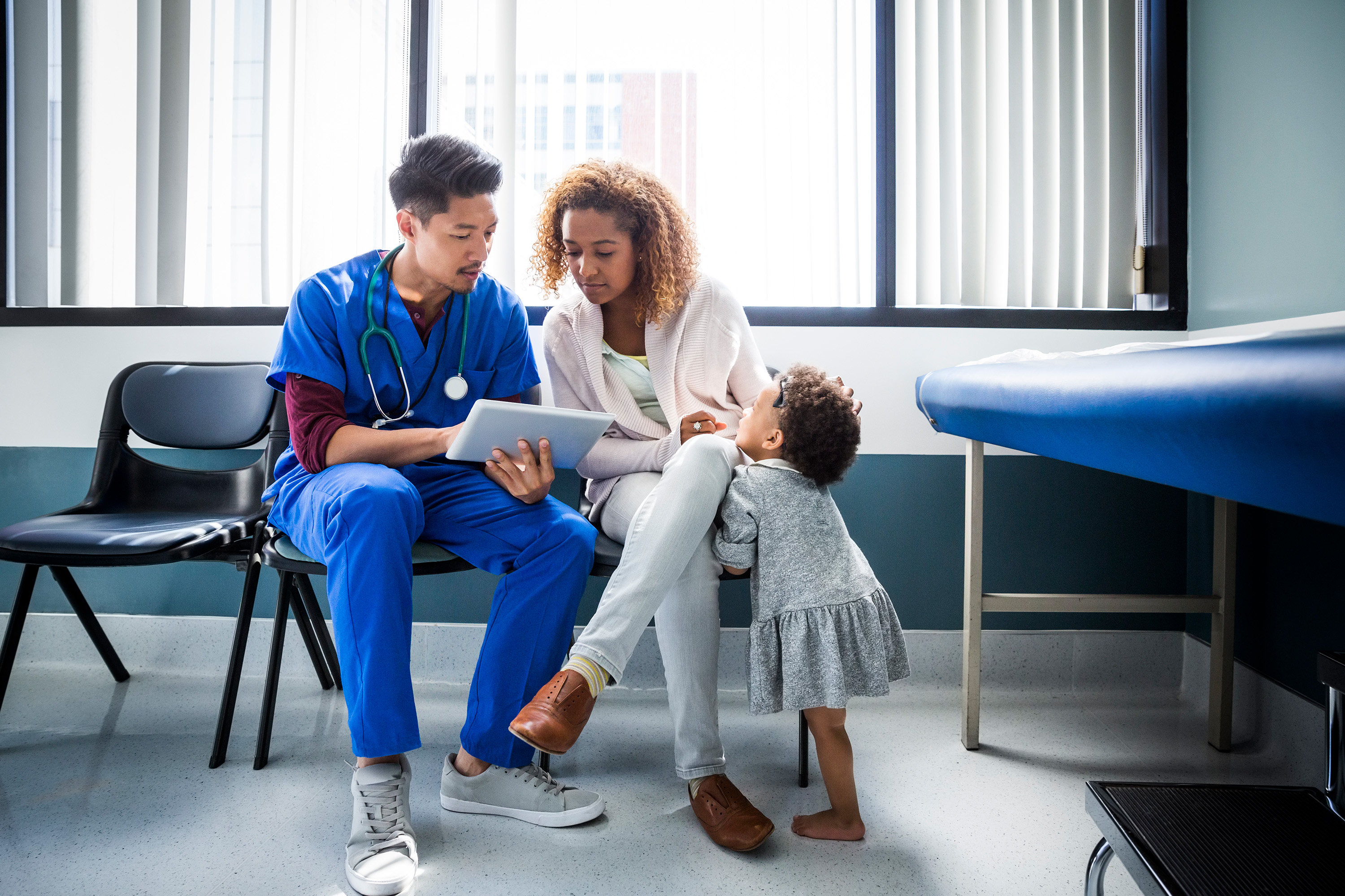 doctor explaining something to a patient and child in the hospital