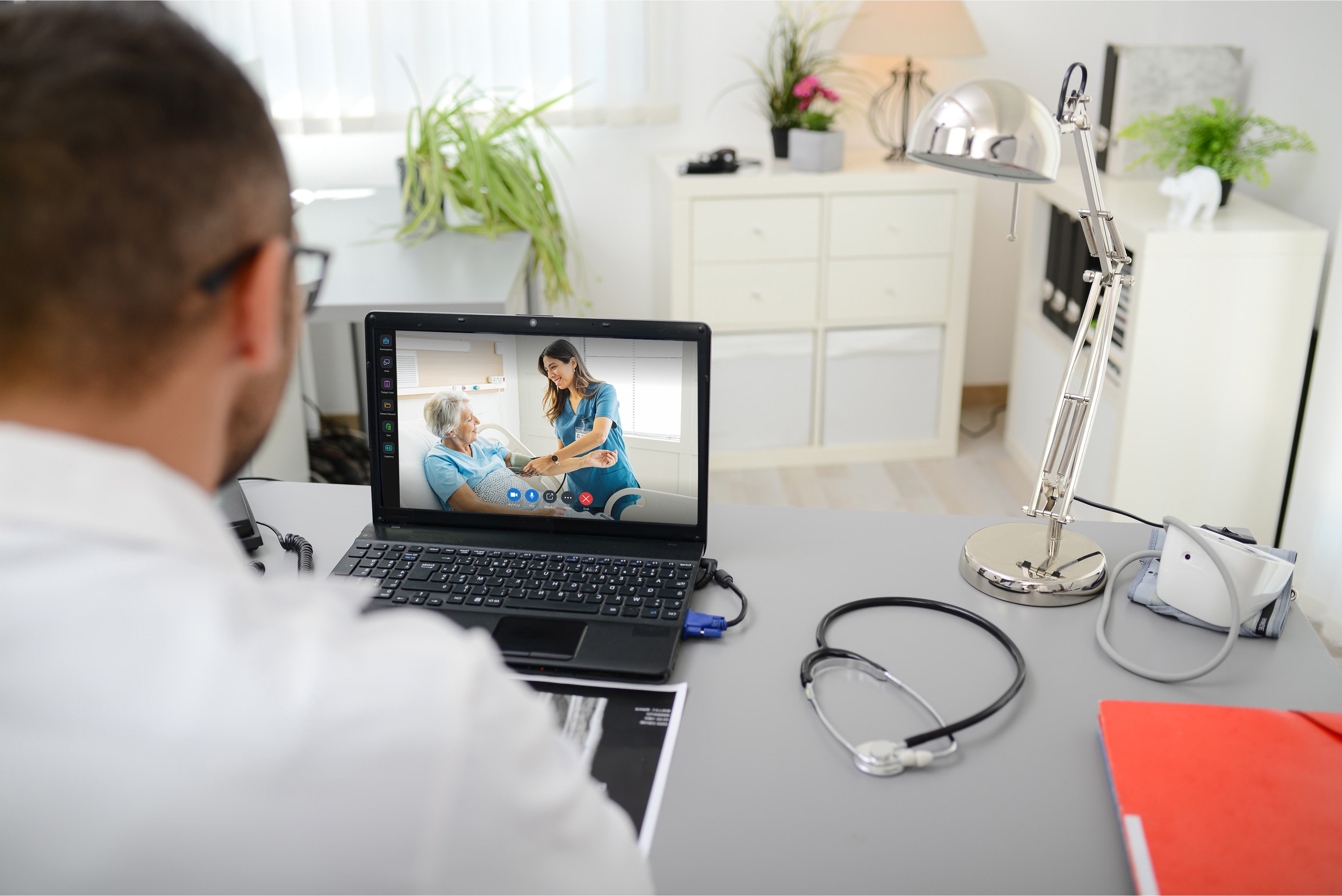 doctors back looking at his laptop in his office